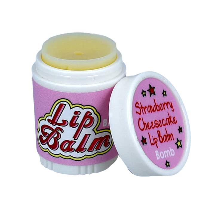 Lip care product in a container featuring a twist-off cap. The container is predominantly pink with the words "Lip Care" in bold, colorful lettering on the front. The cap is slightly open, revealing a pale yellow lip balm inside. Next to it, a smaller lid displays the text "Strawberry Cheesecake Lip Balm Bomb" along with a floral design. The overall design suggests a playful and soothing lip care product.